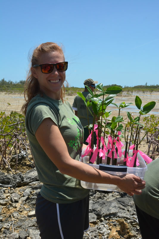 Forest Heights Academy Biology teacher, Lindsey Borsz bounces into action, ready to plant the mangroves.
