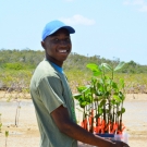 Before planting the mangrove propagules, student must wade out into the mangrove mud. This Abaco Central High School student generously carries the mangrove seedlings to their new home.