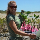 Forest Heights Academy Biology teacher, Lindsey Borsz bounces into action, ready to plant the mangroves.