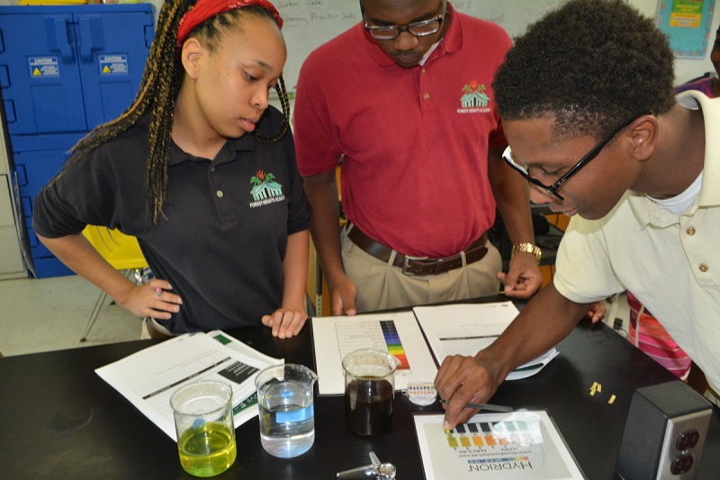 Year 2 B.A.M. participants from Forest Heights Academy, test the pH of various liquids.
