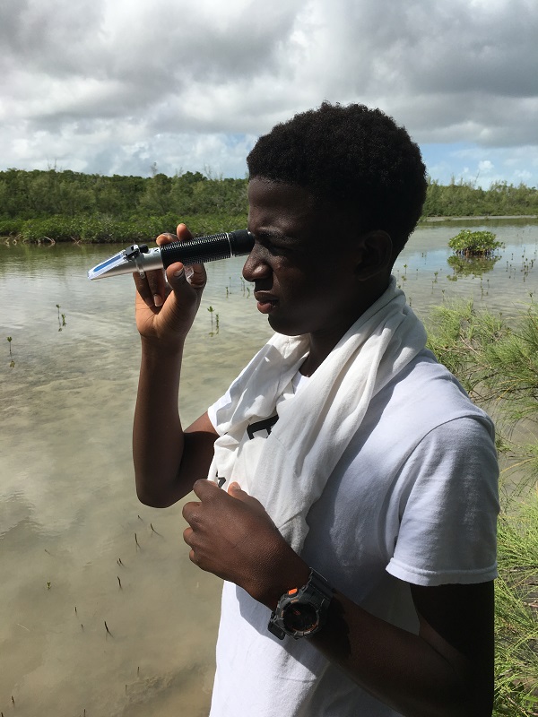B.A.M. second year student reads the salinity of the mangrove ecosystem using a refractometer.