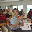 Forest Heights Academy student holds up his three mangrove seedlings that he is going to plant during today's class.