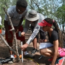 Students create the first corner of their square plot by hammering a PVC pipe into the ground.