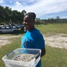 A brave student from Abaco Central High School fills the plant flat with mangrove mud. It's a dirty job, but she was happy to do it.