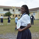 Students at Abaco Central High School participate in a food web activity. Each student is given an animal or plant that can be found in the mangrove food web. A young lady shows that she will be portraying turtle seagrass.