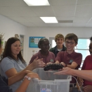 Students at Forest Heights Academy hold a sea cucumber. Some students are holding this organisms for the first time.