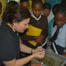 Director of Education, Amy Heemsoth holds a crab up for students to see. She points out the jointed appendages and exoskeleton that the animal possesses and she shows students how they can determine the sex of the animal.