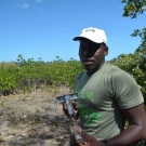 Forest Heights Academy 12th grade Marine Biology student collects a soil sample from his group's quadrat.