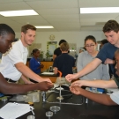 Students at Forest Heights Academy sterilize tweezers and scissors over an open flame before they use them to cut or pick up the diseased mangrove leaves. This prevents contamination.