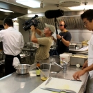 Doug Allan and Curig Huws filming the chefs busily preparing supper in the galley for the Golden Shadow Ship Tour video.