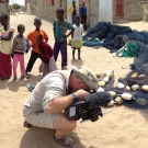 Filming a fishermen repairing his net.