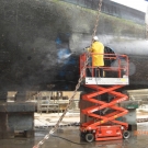 The process of high pressure washing over 1000m2 of steelwork begins. This process removes the algae & barnacles, but not the existing paint.