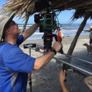 Cameraman James Ball filming on the beach in Honduras.