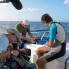 CAPT Phil Renaud and Dr. Sam Purkis explain scientific equipment to the film crew.