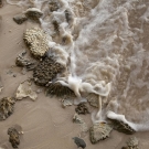 Waves breaking among the coral rubble tossed up on the beach along Middle Brother.