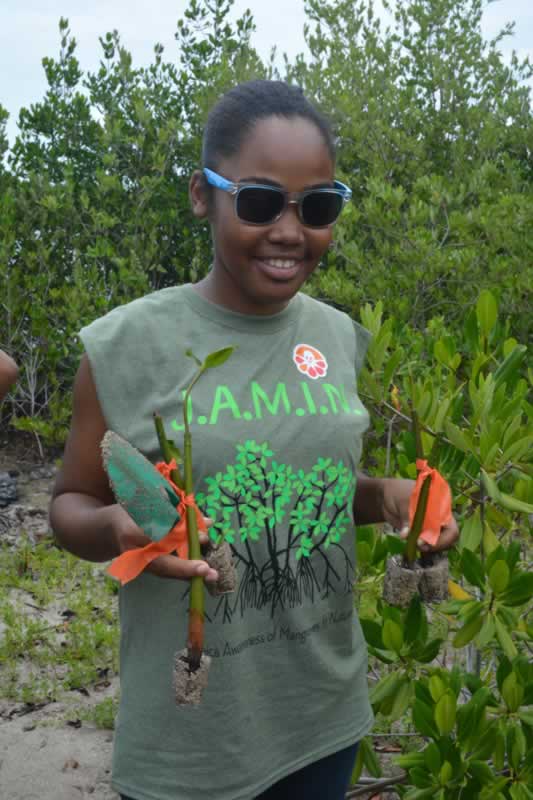 A young lady from Holland High School proudly holds up her mangrove propagules.