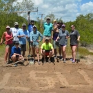 Alumni from Louisiana State University volunteer during their vacation to help remove old stumps and level soil at the JAMIN mangrove restoration site.