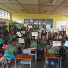 Students at William Knibb High School hold up their certificates to celebrate a successful end of the JAMIN program.