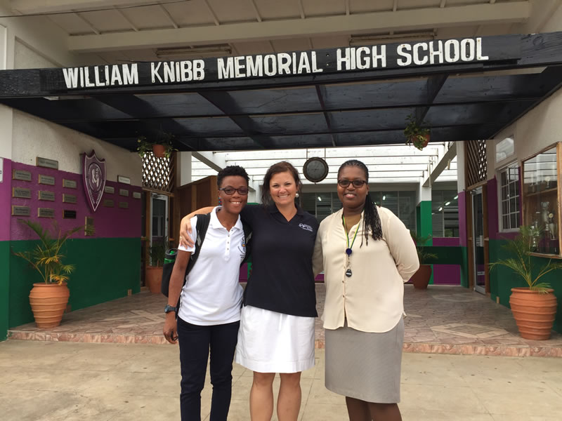 Shanna Thomas (Outreach Officer, University of the West Indies), Amy Heemsoth (Director of Education, Living Oceans Foundation), and Fulvia Nugent (Science Teacher, William Knibb High School) stand at the entrance of the school.