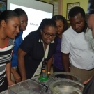 Science teachers lean over the tanks to take a closer peak at a sea anemone.