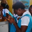 A young woman at William Knibb High School examines a sea cucumber more closely. She said that she had never seen one before.