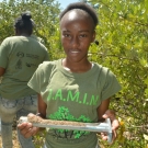 William Knibb High School student shows off her soil sample before she labels and places it in her collection bag. Later she and her group will determine the contents.