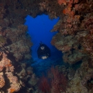 Fellow Anderson Mayfield SCUBA diving through a cave.