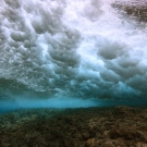 Wave crashing above a reef near Huon. 