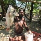 A fisherman shows off his prize catch: a large snapper. 