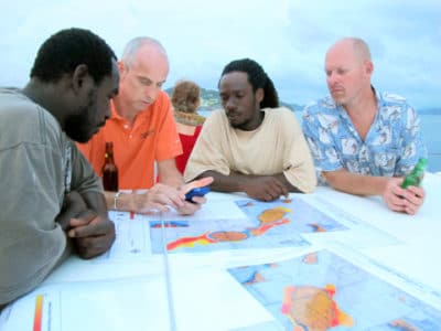 James Byrne shows two fishermen a photo of a lionfish