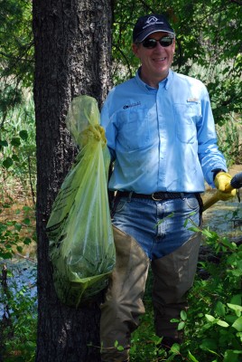 Executive Director, Philip Renaud, emerges from the water while cleaning up our local wetland