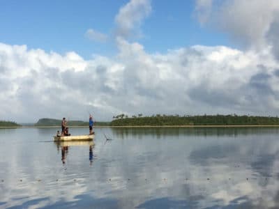 Tonga fishermen push their loaded down boat back to the Koloa shore.