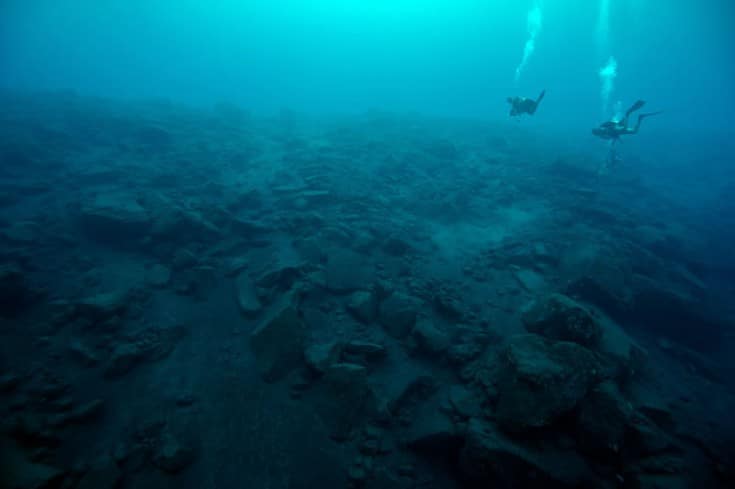 Science divers survey the underwater landscape under Tinakula, barren from the most recent eruption.