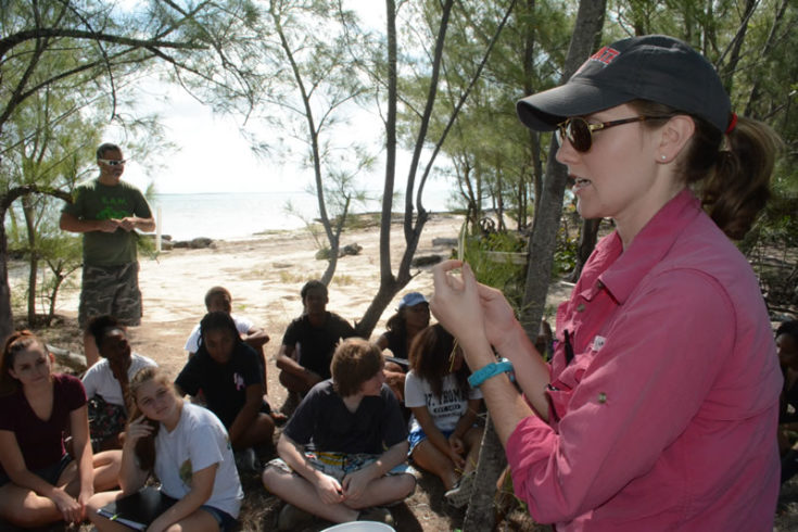 Ryann explains to students how to identify diseased red mangrove leafs at field trip site.