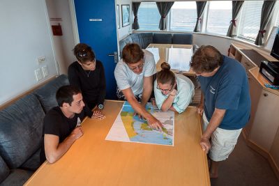 KSLOF Scientists review great barrier reef zoning map aboard golden shadow.