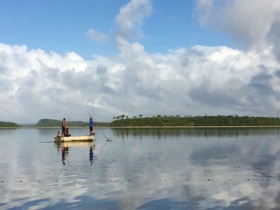 Tonga fishermen push their loaded down boat back to the Koloa shore.